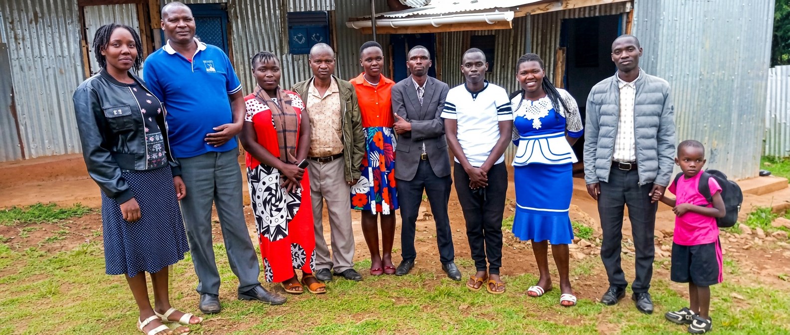 The staff team of Vision of Joy School standing together outside the classrooms